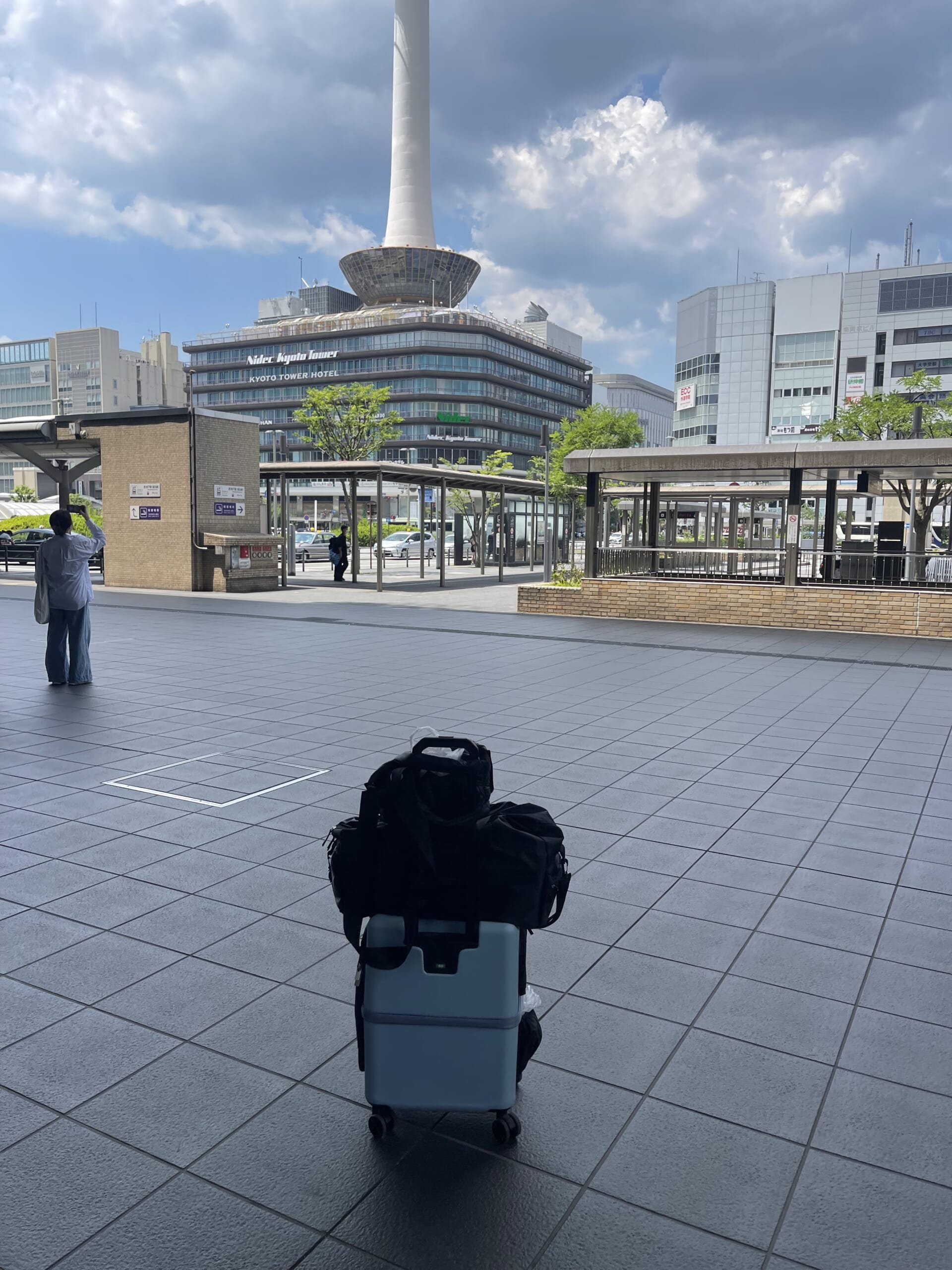 京都タワーを背景に京都駅前で撮った淡いブルーのペチコ